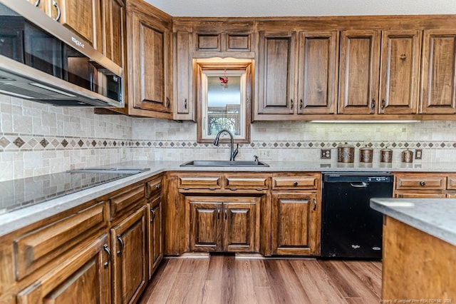 259 Golf Dr, Sanford, NC 27332 - kitchen with black dishwasher, stainless steel microwave, a sink, backsplash, and dark wood-style floors