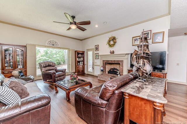 259 Golf Dr, Sanford, NC 27332 - living room featuring ceiling fan, wood finished floors, a brick fireplace, crown molding, and a textured ceiling