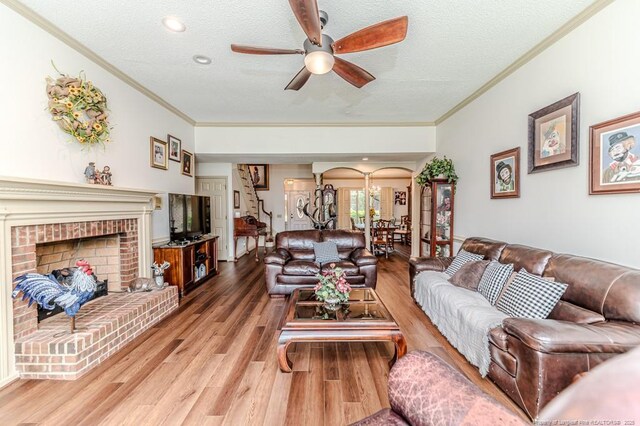 259 Golf Dr, Sanford, NC 27332 - living area with crown molding, arched walkways, a ceiling fan, a textured ceiling, and light wood-type flooring