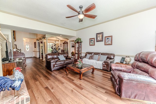 259 Golf Dr, Sanford, NC 27332 - living room featuring decorative columns, a ceiling fan, crown molding, light wood-style floors, and arched walkways