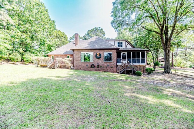 259 Golf Dr, Sanford, NC 27332 - rear view of house featuring stairway, a sunroom, a chimney, brick siding, and a yard