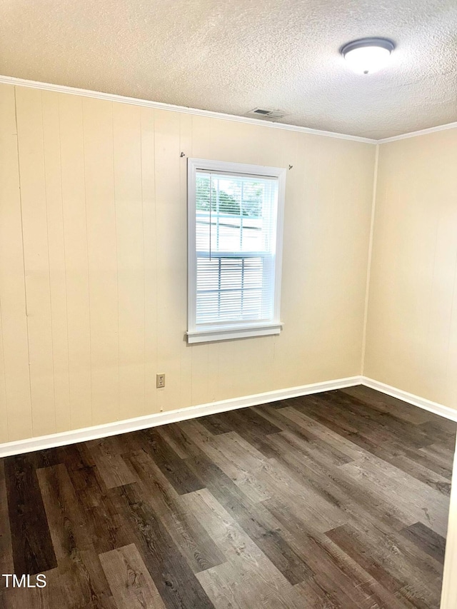 102 E Nash St, Elm City, NC 27822 - spare room with a textured ceiling, dark wood-style flooring, ornamental molding, and baseboards
