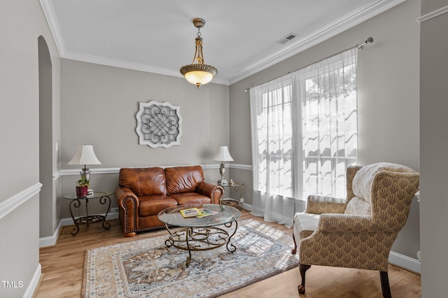 648 Long Melford Dr, Rolesville, NC 27571 - living room with arched walkways, ornamental molding, wood finished floors, and baseboards