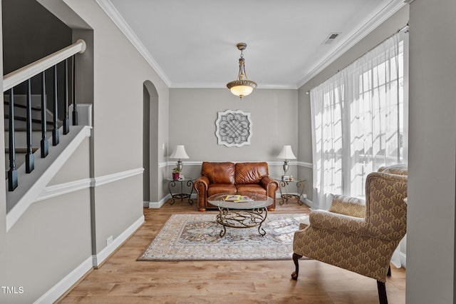 648 Long Melford Dr, Rolesville, NC 27571 - living area with healthy amount of natural light, ornamental molding, arched walkways, wood finished floors, and stairs