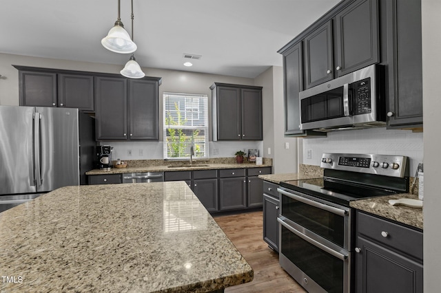 648 Long Melford Dr, Rolesville, NC 27571 - kitchen with appliances with stainless steel finishes, a sink, light stone countertops, and wood finished floors