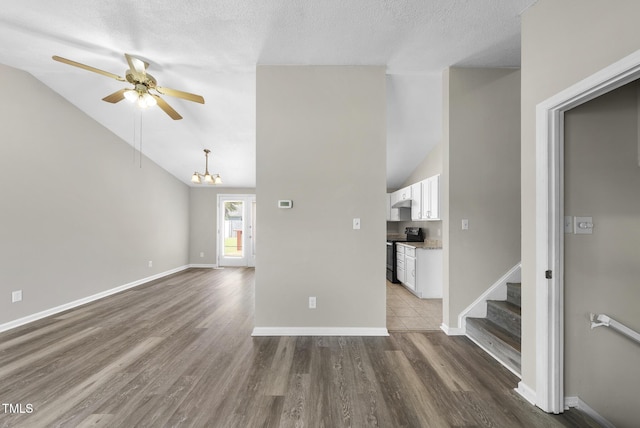 5529 Wood Pond Ct, Raleigh, NC 27610 - unfurnished living room featuring lofted ceiling, ceiling fan, wood finished floors, stairs, and a chandelier