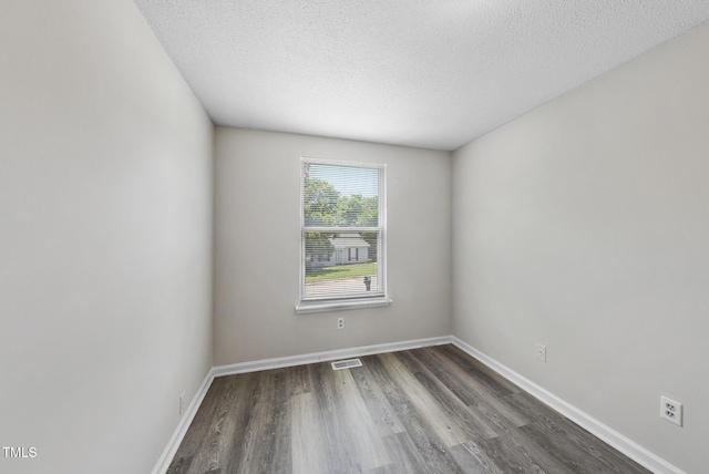 5529 Wood Pond Ct, Raleigh, NC 27610 - empty room featuring dark wood-type flooring, a textured ceiling, and baseboards