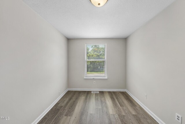 5529 Wood Pond Ct, Raleigh, NC 27610 - spare room featuring wood finished floors, baseboards, and a textured ceiling