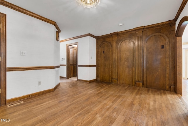 1164 Keith Hills Rd, Lillington, NC 27546 - unfurnished room with light wood-style floors, arched walkways, crown molding, baseboards, and a chandelier