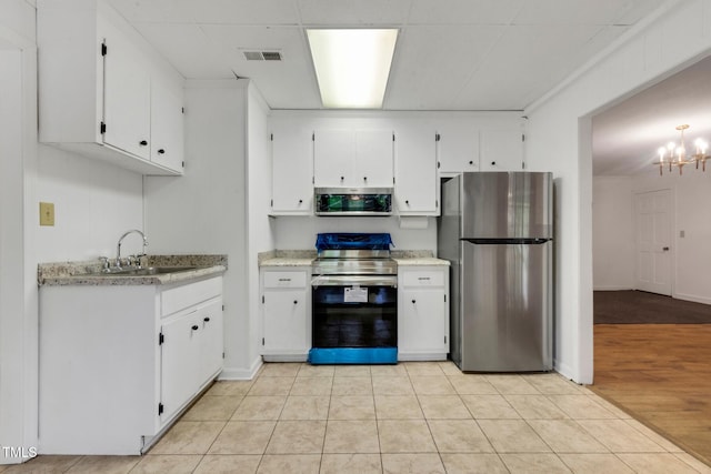 1164 Keith Hills Rd, Lillington, NC 27546 - kitchen with stainless steel appliances, a sink, white cabinetry, and a chandelier