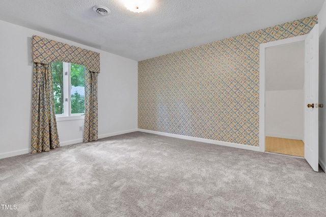 1164 Keith Hills Rd, Lillington, NC 27546 - spare room featuring wallpapered walls, a textured ceiling, carpet, baseboards, and an accent wall