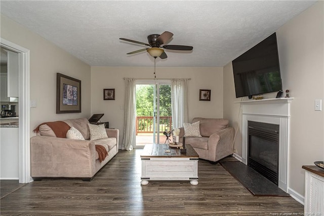 3538 Gables Dr, Fayetteville, NC 28311 - living room featuring a glass covered fireplace, a ceiling fan, dark wood-style flooring, a textured ceiling, and baseboards