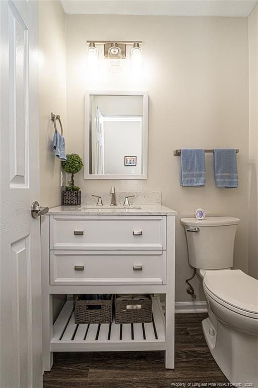 3538 Gables Dr, Fayetteville, NC 28311 - bathroom featuring wood finished floors, vanity, baseboards, and toilet