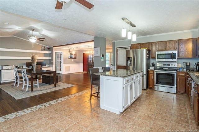 5621 Monks Walk Ct, Fayetteville, NC 28311 - kitchen featuring stainless steel appliances, ceiling fan, a textured ceiling, crown molding, and a kitchen island
