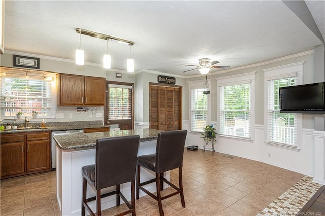5621 Monks Walk Ct, Fayetteville, NC 28311 - kitchen featuring a sink, a kitchen bar, a ceiling fan, brown cabinets, and a textured ceiling