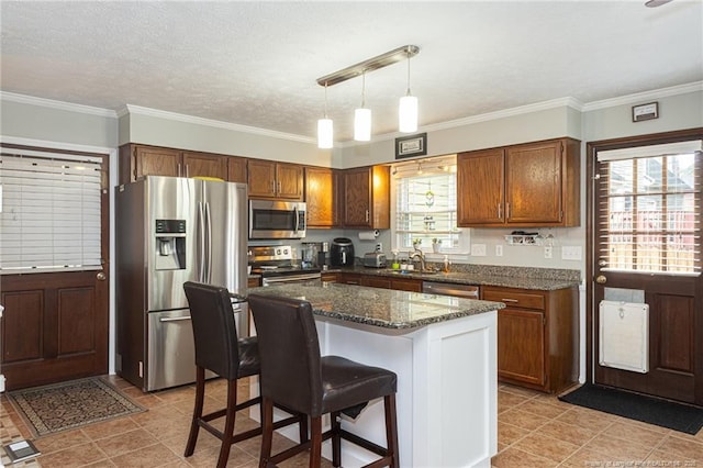 5621 Monks Walk Ct, Fayetteville, NC 28311 - kitchen with stainless steel appliances, a sink, a kitchen bar, pendant lighting, and crown molding