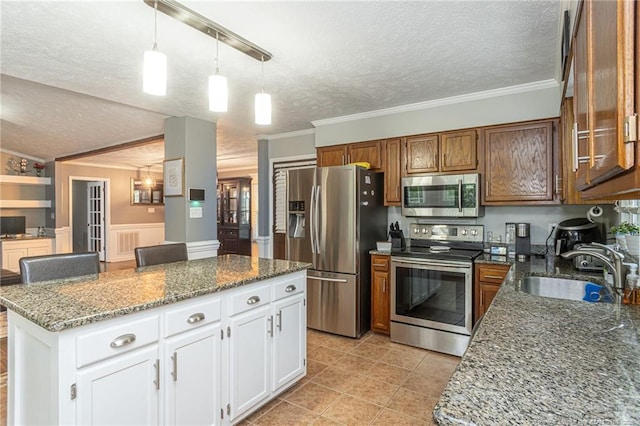 5621 Monks Walk Ct, Fayetteville, NC 28311 - kitchen featuring stainless steel appliances, a sink, a textured ceiling, ornamental molding, and a center island