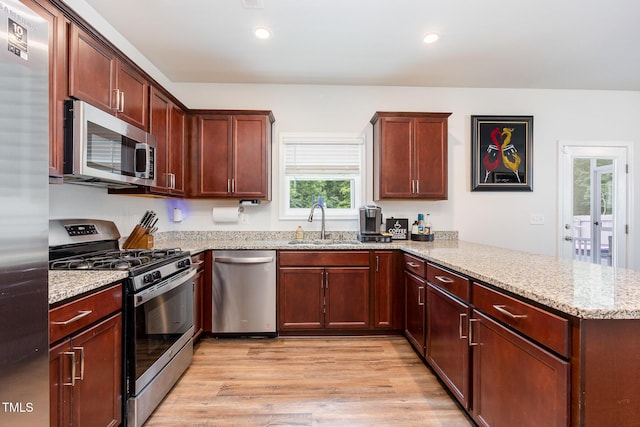 150 Sherrill Place Ln, Garner, NC 27529 - kitchen with appliances with stainless steel finishes, a peninsula, light wood finished floors, light stone counters, and recessed lighting