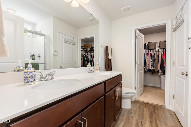150 Sherrill Place Ln, Garner, NC 27529 - bathroom featuring a spacious closet, a shower stall, double vanity, and wood finished floors
