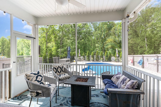 150 Sherrill Place Ln, Garner, NC 27529 - sunroom with ceiling fan, an outdoor living space with a fire pit, and view of wooded area