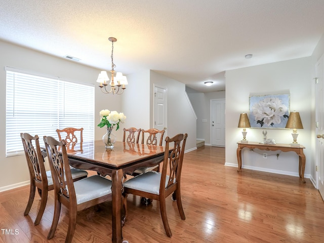 3515 Mountain Brook Cir, Durham, NC 27704 - dining area with a chandelier, light wood-type flooring, and baseboards