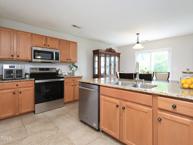 3515 Mountain Brook Cir, Durham, NC 27704 - kitchen with appliances with stainless steel finishes, a sink, light stone countertops, decorative light fixtures, and light tile patterned floors