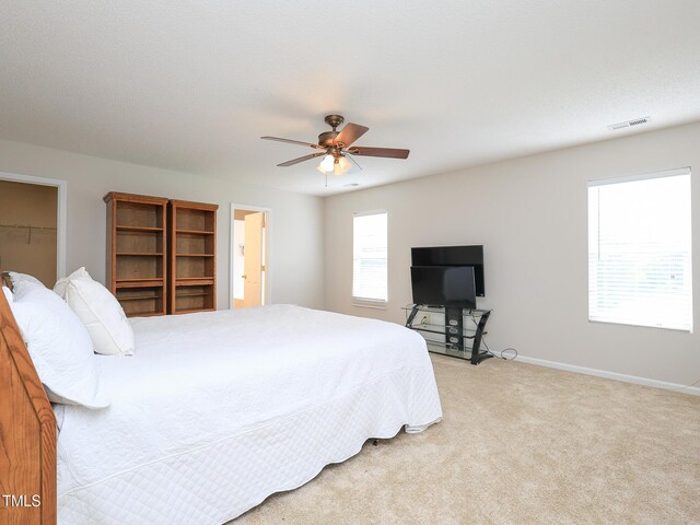 3515 Mountain Brook Cir, Durham, NC 27704 - bedroom with light colored carpet, baseboards, a ceiling fan, and a walk in closet