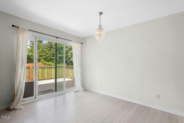 4021 Chaucer Dr, Durham, NC 27705 - empty room featuring a chandelier, wood finished floors, and baseboards