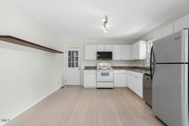 4021 Chaucer Dr, Durham, NC 27705 - kitchen featuring appliances with stainless steel finishes, a sink, white cabinets, dark countertops, and light wood finished floors