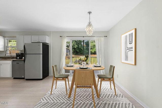 4021 Chaucer Dr, Durham, NC 27705 - dining room featuring a chandelier, light wood finished floors, and baseboards