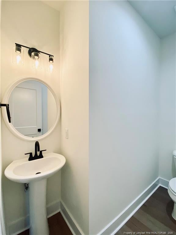 285 Delmore Rd, Autryville, NC 28318 - bathroom with toilet, baseboards, and wood finished floors