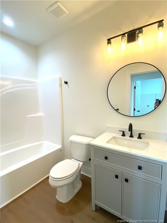 285 Delmore Rd, Autryville, NC 28318 - bathroom featuring vanity, toilet, wood finished floors, baseboards, and bathing tub / shower combination