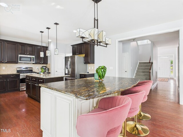 1728 Callandale Ave, Cary, NC 27518 - kitchen featuring stainless steel appliances, a kitchen island, dark wood finished floors, backsplash, and dark brown cabinets