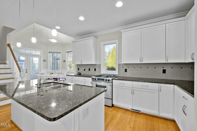 100 Maywood Way, Chapel Hill, NC 27516 - kitchen with stainless steel gas stove, white cabinetry, light wood finished floors, tasteful backsplash, and dark stone counters