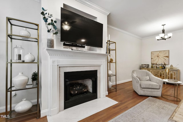222 Ashton Hall Ln, Raleigh, NC 27609 - living area featuring crown molding, wood finished floors, a chandelier, a fireplace with flush hearth, and baseboards