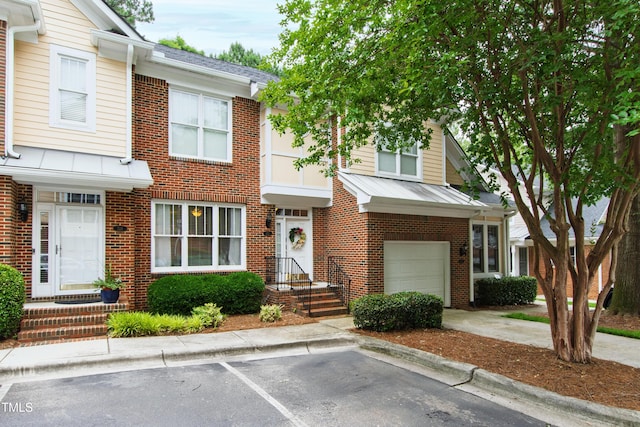 222 Ashton Hall Ln, Raleigh, NC 27609 - multi unit property with brick siding, concrete driveway, a standing seam roof, a garage, and metal roof