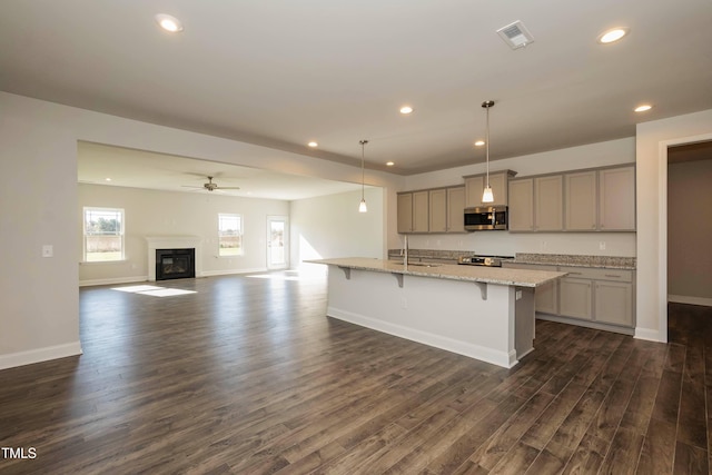 61 Merrifield Ln, Garner, NC 27529 - kitchen featuring stainless steel appliances, gray cabinets, dark wood finished floors, recessed lighting, and a kitchen bar