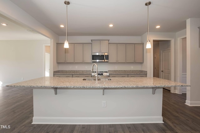 61 Merrifield Ln, Garner, NC 27529 - kitchen with stainless steel microwave, gray cabinetry, a sink, a kitchen breakfast bar, and dark wood finished floors
