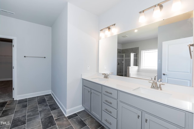 61 Merrifield Ln, Garner, NC 27529 - bathroom with a stall shower, double vanity, a bath, baseboards, and a spacious closet