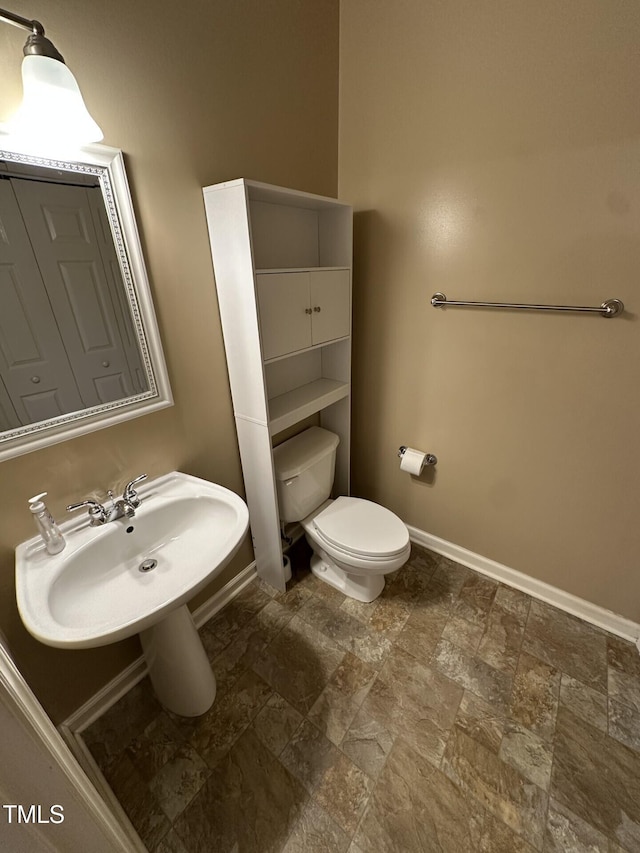 710 N Person St Unit 103, Raleigh, NC 27604 - bathroom featuring stone finish flooring, baseboards, toilet, and a sink