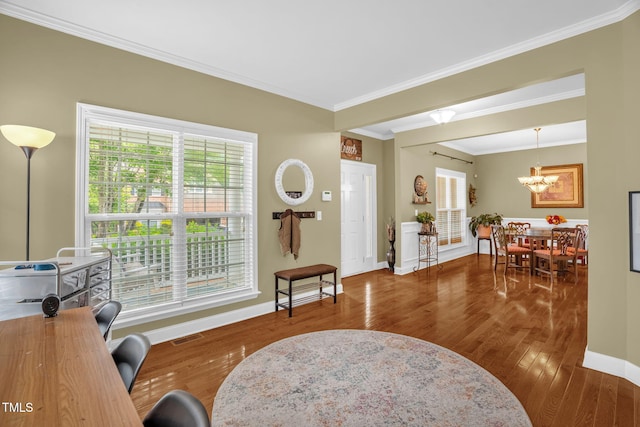 1428 White Opal Dr, Knightdale, NC 27545 - living area featuring wood finished floors, healthy amount of natural light, a chandelier, crown molding, and baseboards