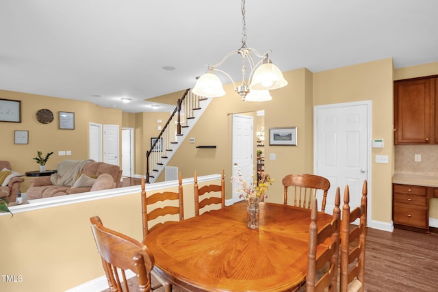 1428 White Opal Dr, Knightdale, NC 27545 - dining area with stairs, a chandelier, dark wood finished floors, and baseboards