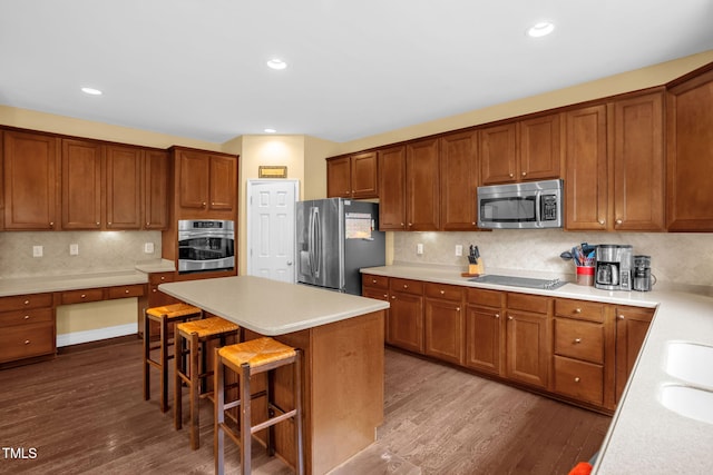 1428 White Opal Dr, Knightdale, NC 27545 - kitchen featuring stainless steel appliances, dark wood-style flooring, backsplash, a breakfast bar, and a center island