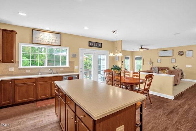 1428 White Opal Dr, Knightdale, NC 27545 - kitchen with a sink, brown cabinets, wood finished floors, light countertops, and recessed lighting