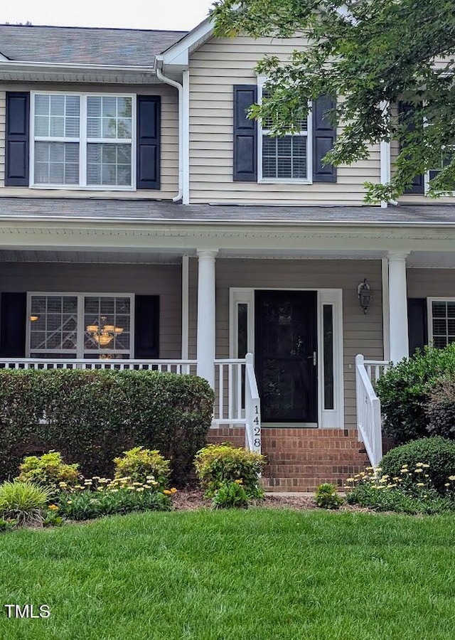 1428 White Opal Dr, Knightdale, NC 27545 - view of front facade with covered porch, a front yard, and brick siding