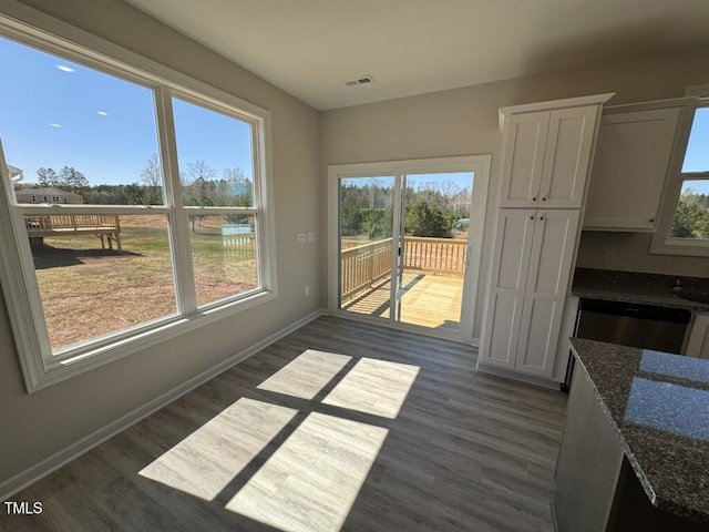 140 Brookhaven Dr, Spring Hope, NC 27882 - unfurnished dining area with dark wood-style floors, plenty of natural light, and baseboards