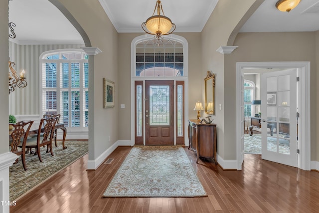 7800 Twin Pines Way, Fuquay Varina, NC 27526 - foyer with arched walkways, hardwood / wood-style floors, baseboards, crown molding, and a chandelier
