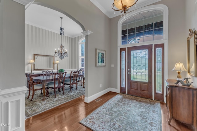 7800 Twin Pines Way, Fuquay Varina, NC 27526 - entryway with a chandelier, arched walkways, ornamental molding, wood finished floors, and a high ceiling