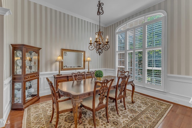 7800 Twin Pines Way, Fuquay Varina, NC 27526 - dining room with wallpapered walls, wood finished floors, wainscoting, a chandelier, and crown molding