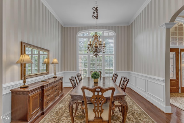 7800 Twin Pines Way, Fuquay Varina, NC 27526 - dining space featuring wallpapered walls, wood finished floors, plenty of natural light, crown molding, and wainscoting